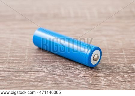 Blue Li-ion Battery On Wooden Table. New 18650 Battery With 3.7 Voltage