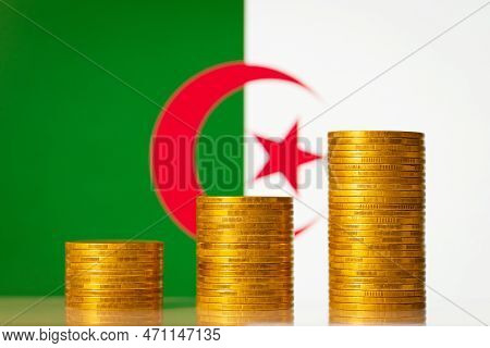 Money Coins Stacks In Front Of Algeria Flag. Development Of Economy Of Algeria Concept