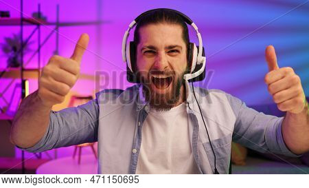 Gamer Bearded Guy, In A Gaming Headset, Wins A Video Game. Cybersportsman In A Neon Room. Lifestyle 