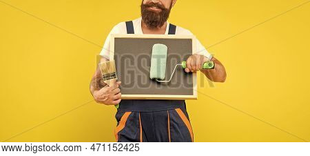 Cropped Man Housepainter Hold Paint Roller Brush And Blackboard With Copy Space On Yellow Background