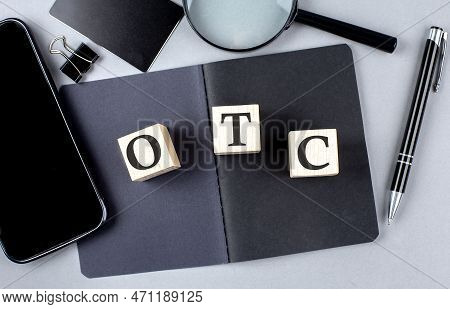 Word Otc Stands For Over-the-counter On A Wooden Block On Black Notebook With Smartpone, Credit Card
