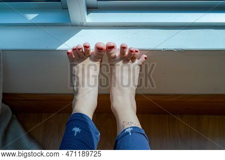Feet With Henna In A Bright Sunlight On The Floor. Drying Henna At Home.