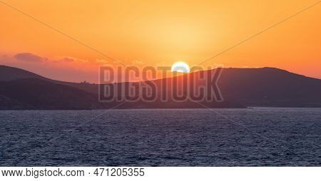 Rocky Island On Mediterranean Sea. Rinia Near Mikonos, Greece, Europe. Nature Background. Sunrise Sk