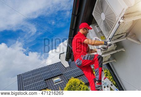 Hat Pump And Air Condition Scheduled Maintenance Performed By Caucasian Hvac Technician In His 40s.