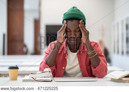 Stressed Tired African American Student Man Touching Temples Have Headache After Long Time Preparing