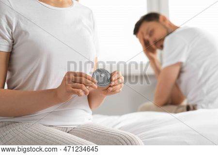 Couple In Bedroom. Woman With Blister Of Emergency Contraception Pill, Closeup