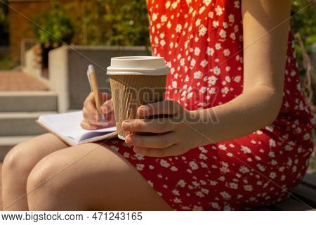 Unrecognizable Young Woman In Red Dress Drinking Coffee From Craft Paper Cup Writing Gratitude Journ
