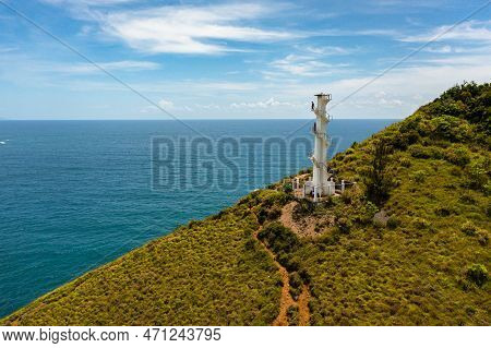 Aerial Drone Of Lighthouse On A Hill Against The Blue Sky. Santa Ana, Luzon, Philippines.