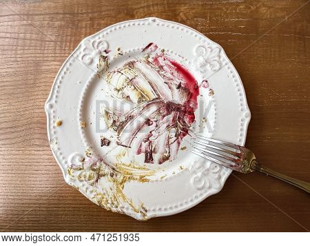 Dirty Plate After Eaten Dessert On The Wooden Table With Fork
