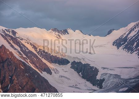 Dramatic Aerial View To High Snow Mountain Range In Early Morning At Dawn. Awesome Scenery With Sunl