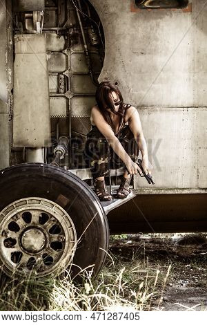 Portrait Of A Young Girl With Mimetic Military Dress Near The Old Abandoned Broken Plane. Concept Mi