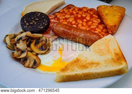 White Board With Full English Breakfast With Bacon, Fried Egg, Beans, Tomato, Roasted Sausage, Black