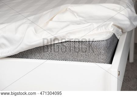 White Satin Sheet On An Elastic Band On The Mattress. Bed Linen On The Bed