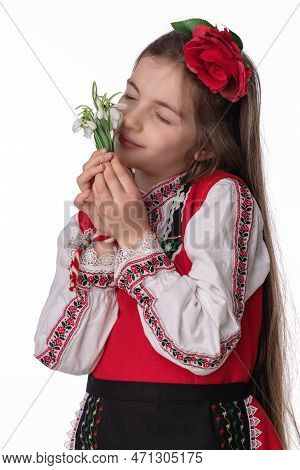 Bulgarian Girl In Traditional Folklore Costumes With Spring Flowers Snowdrop And Handcraft Wool Brac