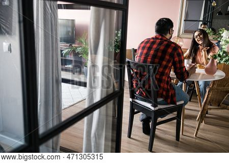 Young Diverse Loving Couple Eating Croissant And Talks Together At Home In Breakfast Time. Communica