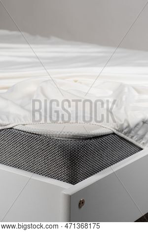 White Satin Sheet On An Elastic Band On The Mattress. Bed Linen On The Bed
