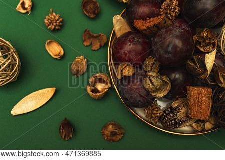 Uicy Plums On A Gold-rimmed Platter. On A Green Background.