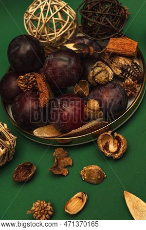Uicy Plums On A Gold-rimmed Platter. On A Green Background.