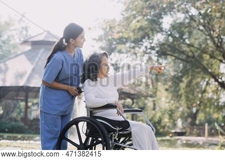 Asian Young Caregiver Nurse Support Senior Older Male Walking Outdoors. Specialist Girl Doctor Help