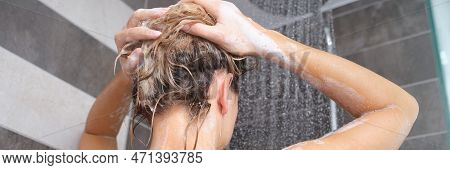 Young Woman Washes Her Hair With Shampoo And Hands With Foam Closeup. Back Of Beautiful Woman Taking