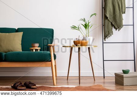 Elegant Living Room With Bottle Green Sofa, Wooden Coffee Table, Cup Of Coffee, Side Table, Decorati