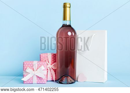 Bottle Of Wine On Colored Background For Valentine Day With Gift Box. Heart Shaped With Presrnt Box 