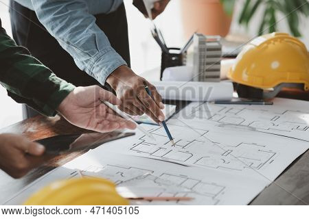 The Home Design Architects Are Reviewing The House Plan Draft, The Project Commissioned By The Clien