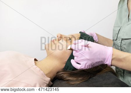 Acne Treatment. Cosmetologist Does Cleaning Skin Mask Procedure On Female Teens Face. Teenage Girl L