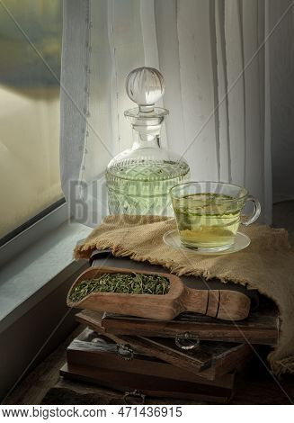 A Cup Of Hot Hemp Tea (cbd Herbal Tea) From Glass Bottle With Dried Organic Hemp Leaves Placed On Sa