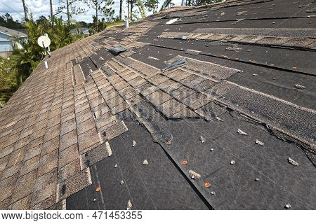 Wind Damaged House Roof With Missing Asphalt Shingles After Hurricane Ian In Florida. Repair Of Home