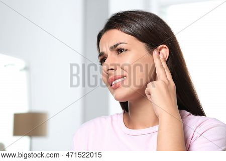 Young Woman Suffering From Ear Pain Indoors, Space For Text