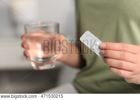 Woman Taking Emergency Contraception Pill In Bedroom, Focus On Hand