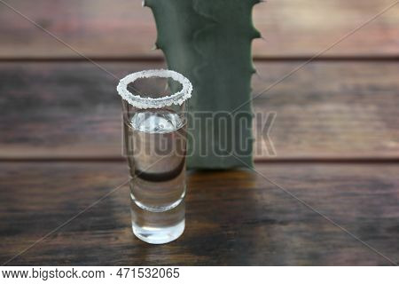 Mexican Tequila Shot With Salt And Green Leaf On Wooden Table, Closeup With Space For Text. Drink Ma