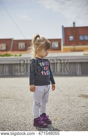 Sad Child Playing On The Embankment In Denmark