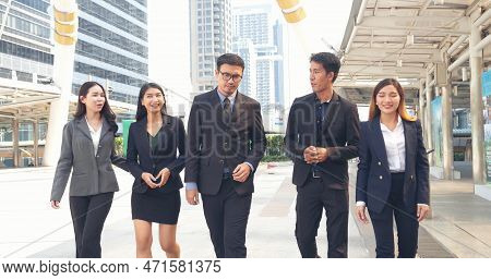 Group Of Business People Asian Team Partners Walking In City Happy Together. Leader Executive Men St