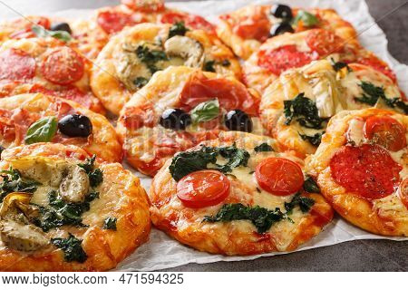 Pizzette Italian Mini Pizzas Or Pizza Bites Close-up On Parchment On The Table. Horizontal