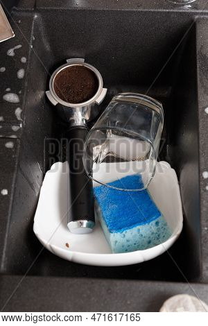 Washing Dishes Concept. Dirty Dishes With Foam From Detergent In A Black Stone Sink In The Kitchen T
