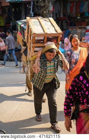 Kathmandu, Nepal, 04 23 2022: Man Carrying Stacked Goods On His Head
