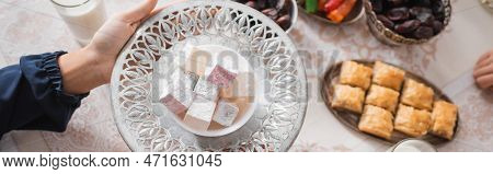 Top View Of Muslim Woman Holding Plate With Turkish Delight During Suhur And Ramadan, Banner.