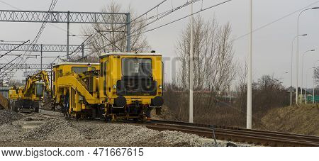 Construction Of New Railway Tracks. Construction Work On Rails. An Excavator Running On Railroad Tra