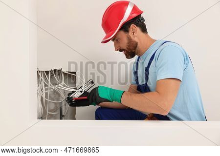 Electrician With Screwdriver Fixing Patch Panel Indoors