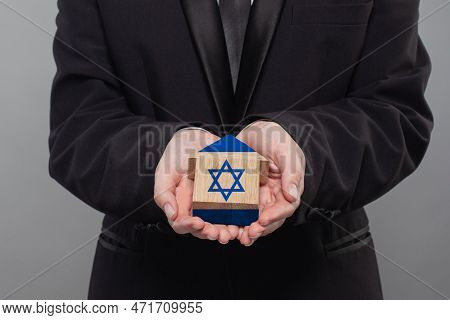 Izraeli Person Holding Wooden House With Flag Of Izrael Finance, Investment, Mortgage, Loan And Cred
