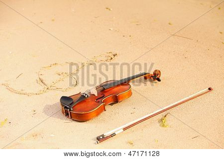 Violino e G Clef sulla spiaggia. Concetto di musica