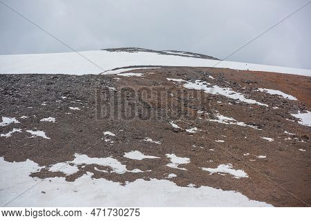 Dramatic Landscape With Huge Rock Mountain With Snowy Mountain Dome Under Gray Cloudy Sky. Awesome S