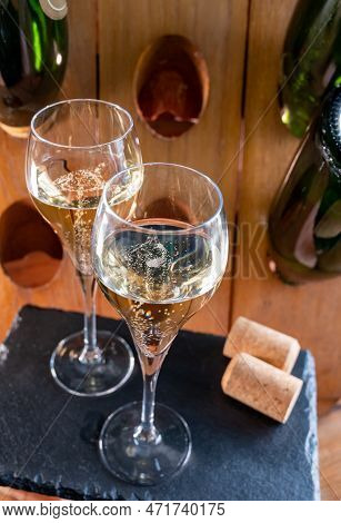Glasses Of Sparkling White Wine Champagne Or Cava With Bubbles And Classic Wooden Champagne Pupitre