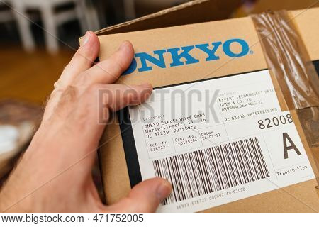 Frankfurt, Germany - Feb 23, 2023: Pov Male Hand Holding New Onkyo Cardboard Of A Video Audio Home C