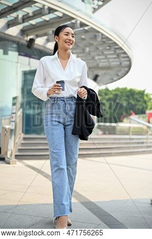 Gorgeous Asian Businesswoman Walking Outside Of The Company Building With Her Takeaway Coffee Cup.