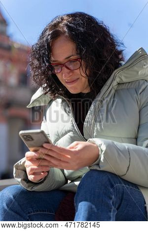 Woman Chatting With Her Smartphone In A Sunny Day
