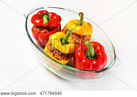 A Picture Of An Unbaked Yellow And Red Stuffed Peppers Served In A Heatproof Glass
