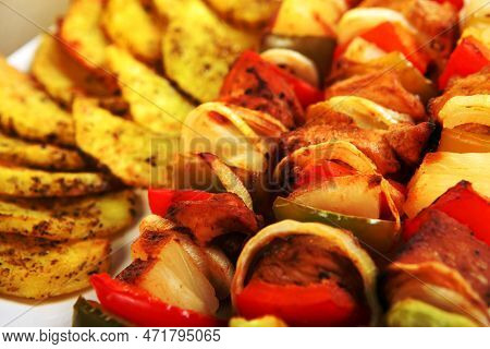 A Close-up Of Fresh Polish Chicken Shashlick With Baked Potatoes On A White Plate